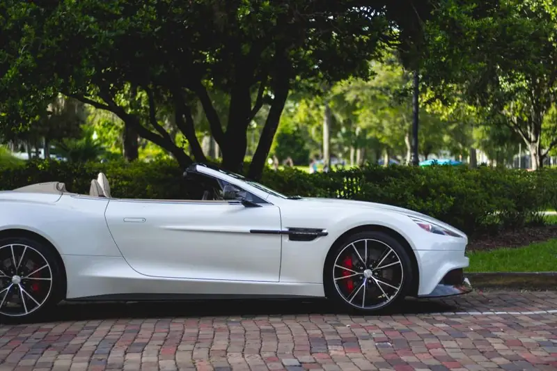 Silver convertible parked under trees