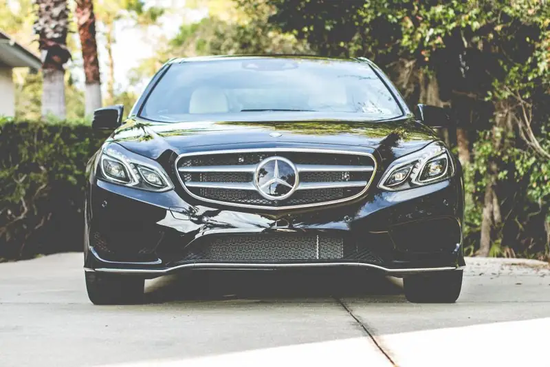 Black sedan parked in a driveway, freshly detailed