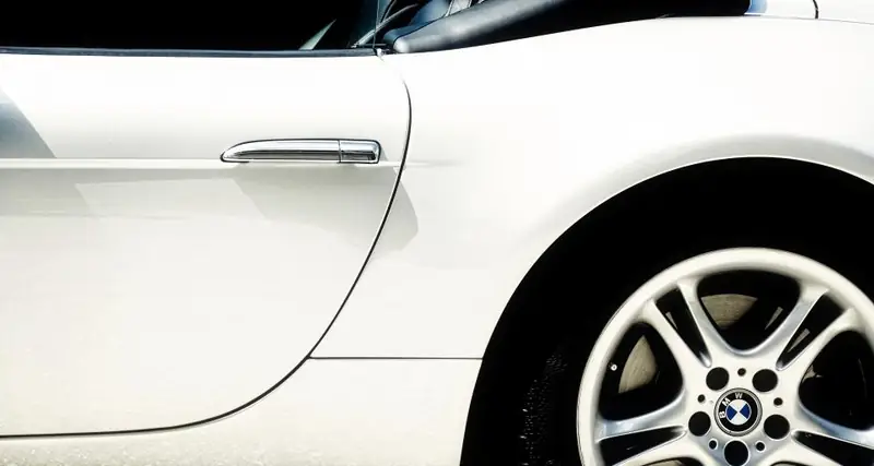 Side of a white roadster with a polished wheel