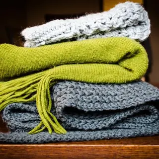 Folded knitted throw blankets in grey and green